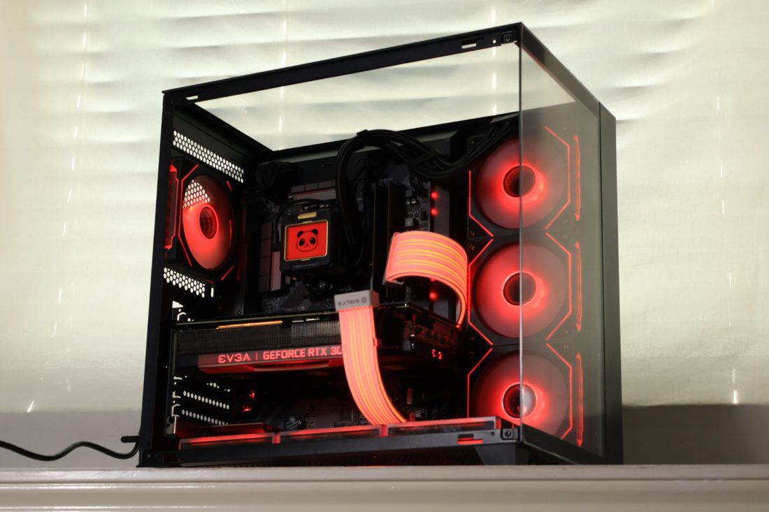 A custom gaming PC with red-lit fans in a glass case